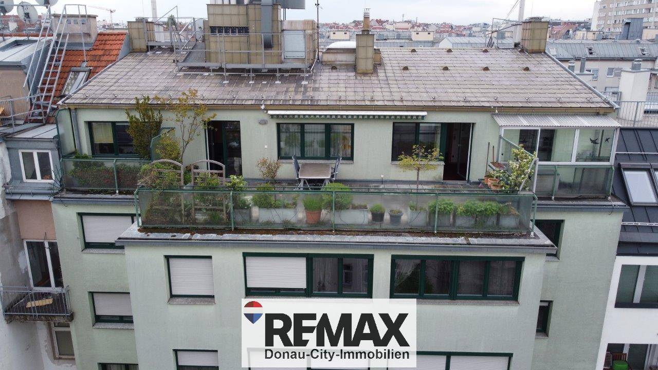 Gebäudeansicht mit großer Dachterrasse und Pflanzen auf mehreren Ebenen.
