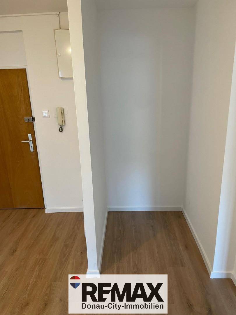 Heller Flurbereich mit Laminatboden und einer praktischen Nische, ideal für Garderobe oder Stauraum.