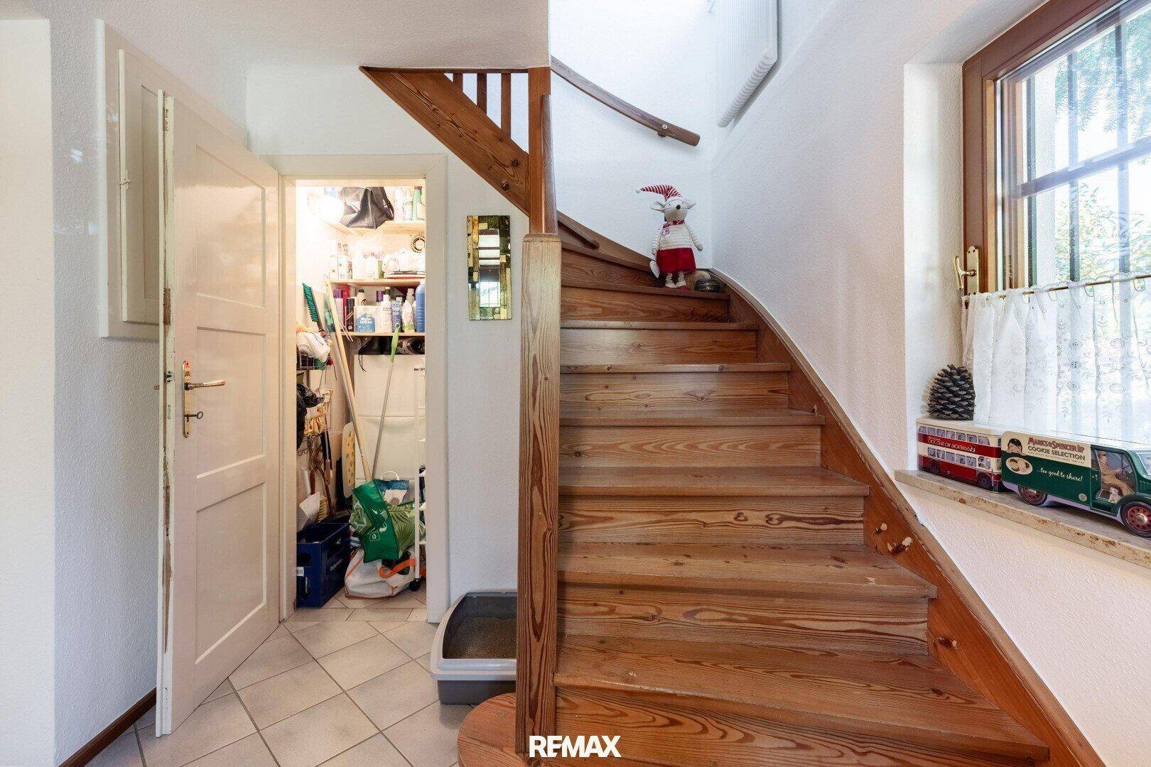 Holztreppe führt in den oberen Bereich, mit einem praktischen Abstellraum im Erdgeschoss.