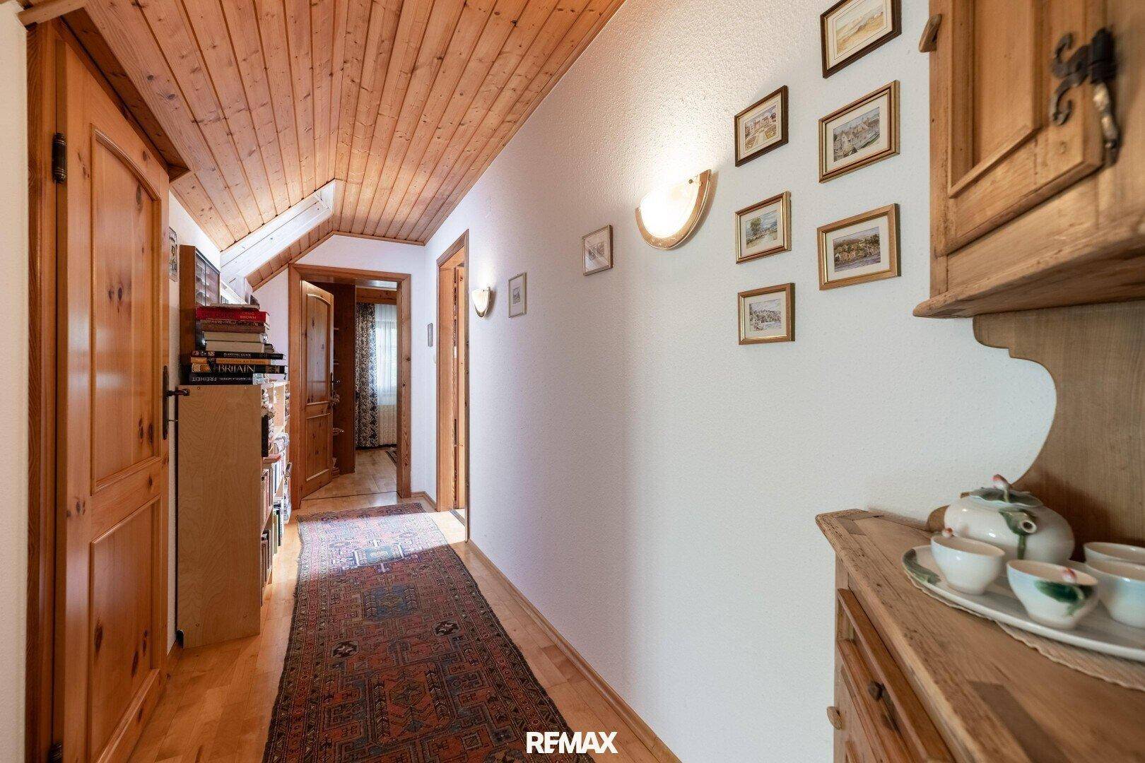 Gemütlicher Flur mit Holzdecke, Holzboden und traditioneller Dekoration an den Wänden.