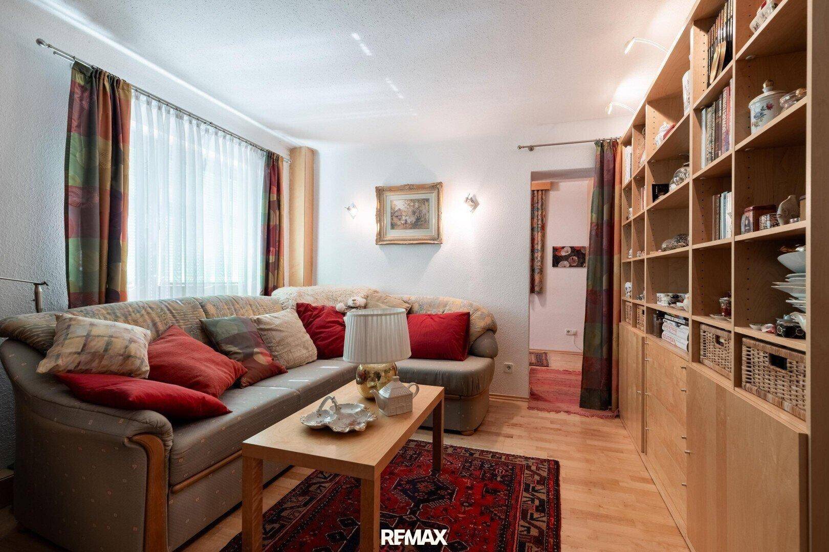 Gemütlicher Wohnbereich mit Sofa, Couchtisch und großer Bücherwand.
