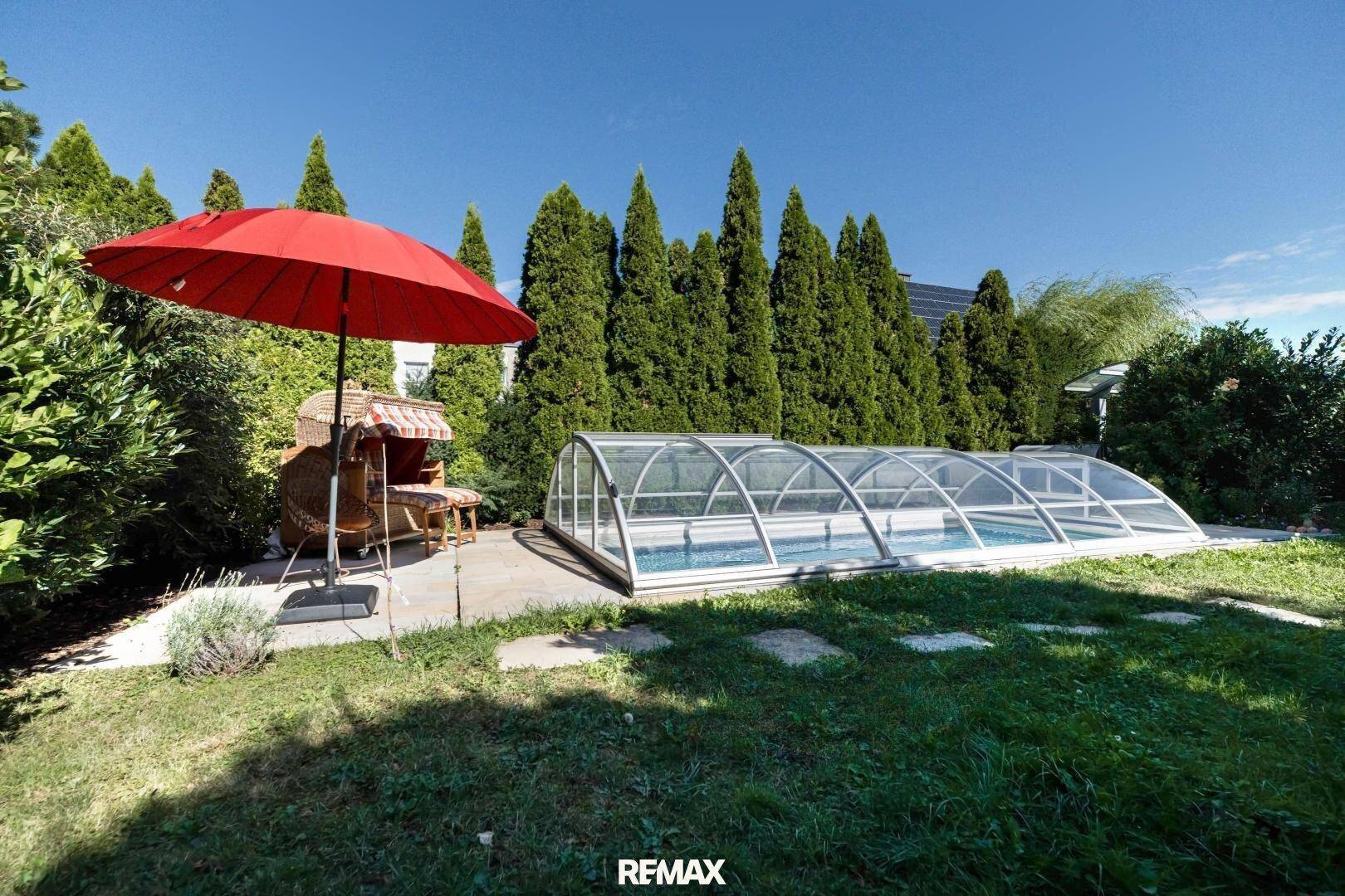 Großer Garten mit überdachtem Pool und viel Grün, perfekt für sonnige Tage.