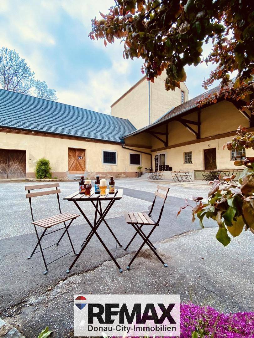 Gemütlicher Außenbereich im Innenhof mit kleinem Tisch und Stühlen, ideal für entspannte Stunden.