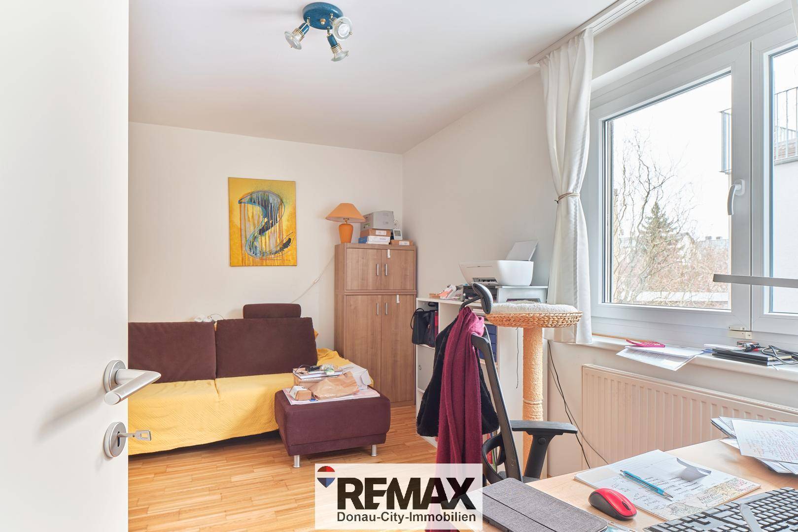 Arbeitszimmer mit Holzboden, Fenster und Schreibtisch.