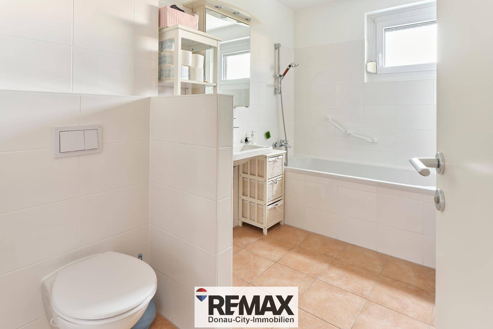 Modernes Badezimmer mit Badewanne, WC und weißen Fliesen.
