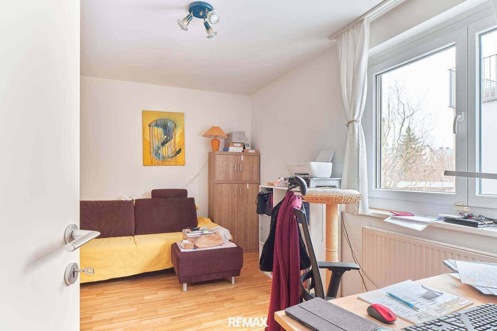 Schlafzimmer mit Holzboden, Fenster und Schreibtisch, ideal als Kinder- oder Arbeitszimmer.
