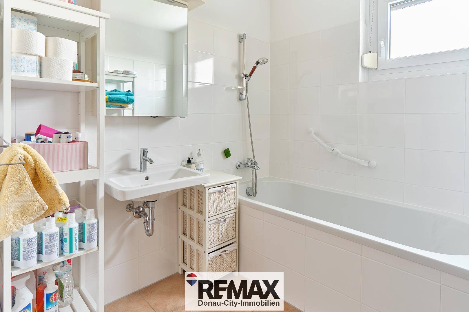 Helles Badezimmer mit Badewanne, Waschbecken und Spiegelschrank.