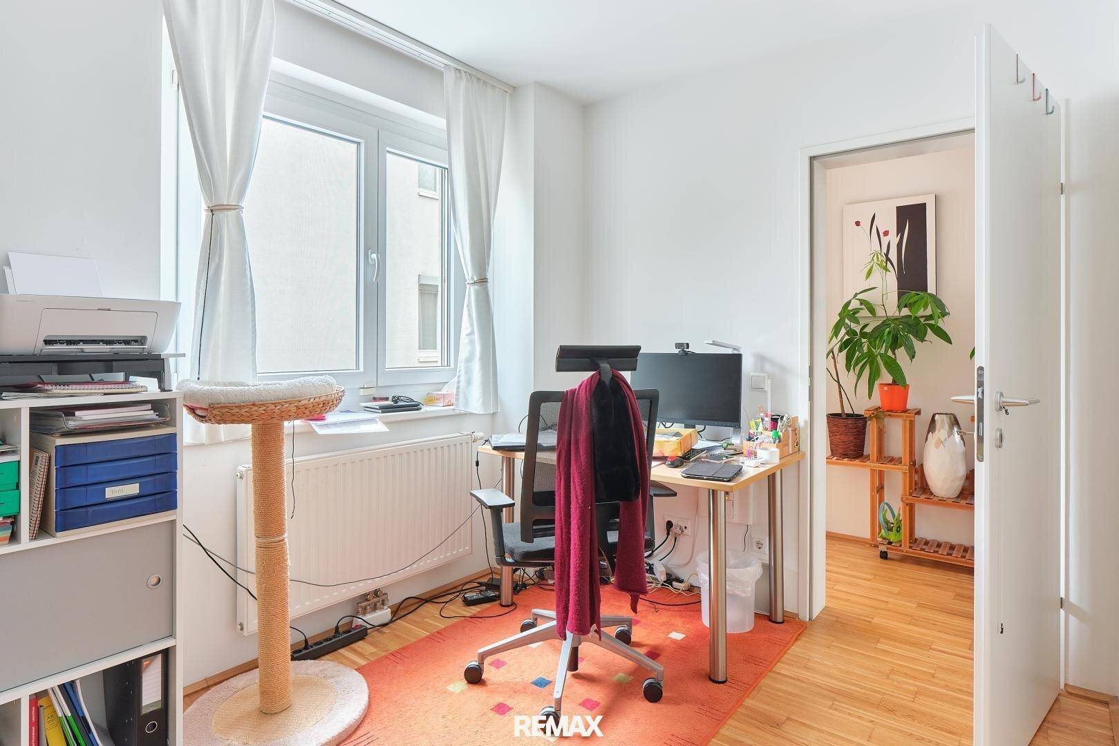 Helles Arbeitszimmer mit Schreibtisch, Bürostuhl und Fenster, ideal für Home-Office.