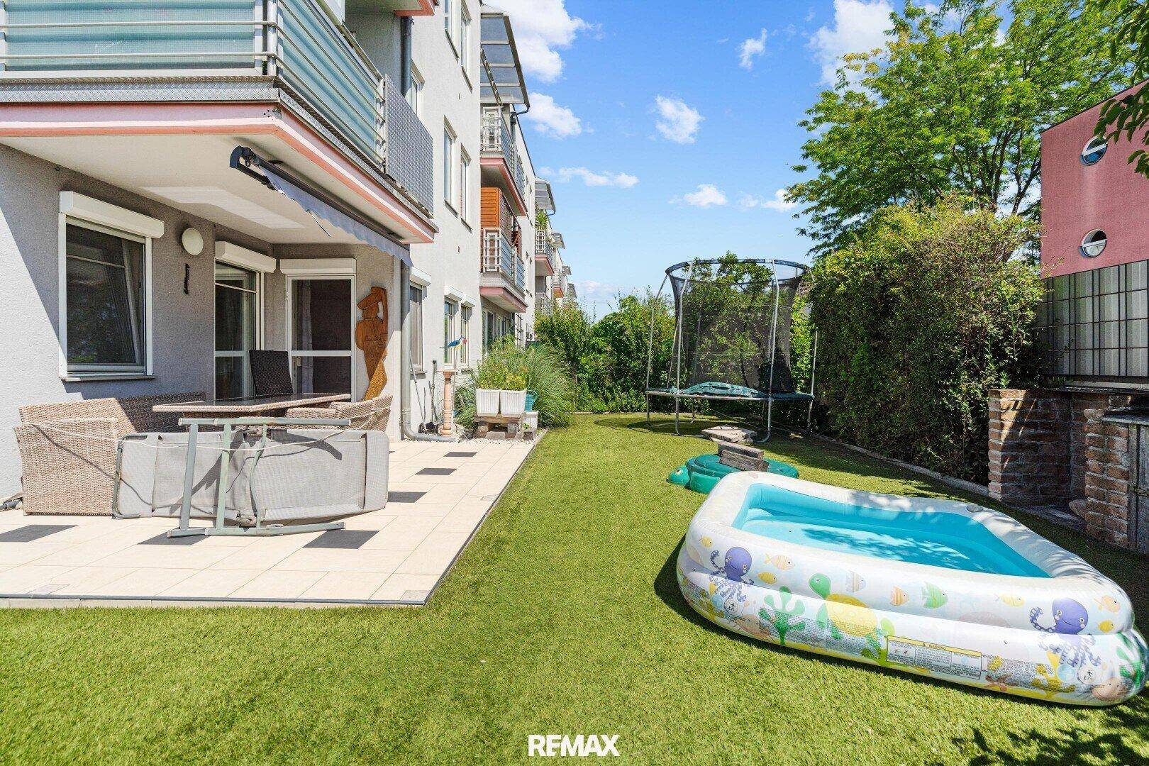 Großer Garten mit Terrasse, Trampolin und Planschbecken, ideal für Familien und Entspannung.