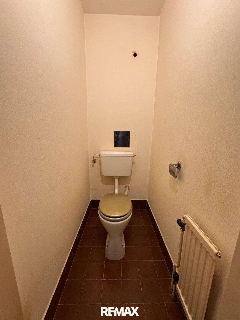 Separates WC mit Toilette und Fliesenboden, funktional und einfach gehalten.