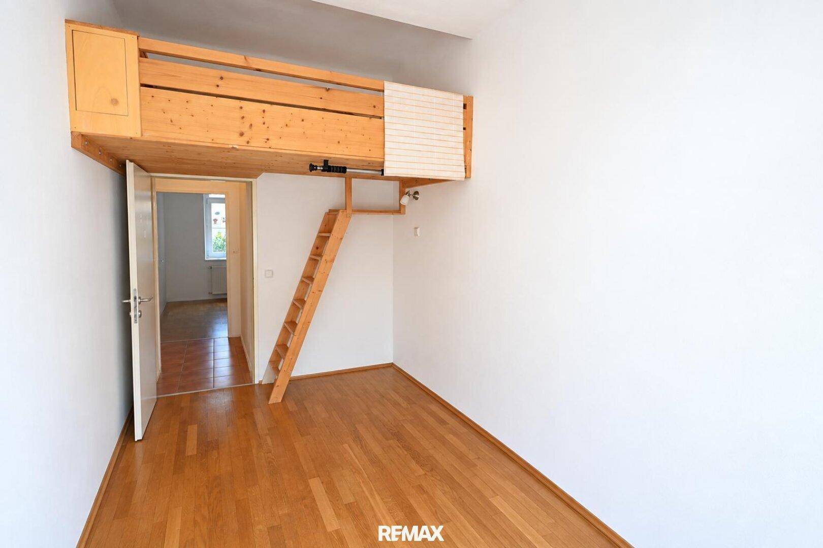 Helles Zimmer mit Holzboden und integriertem Hochbett mit Leiter, bietet eine platzsparende Schlaflösung.