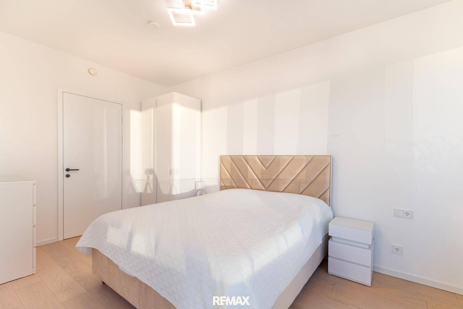 Geräumiges Schlafzimmer mit hellem Interieur, Einbauschrank und Nachttischen.