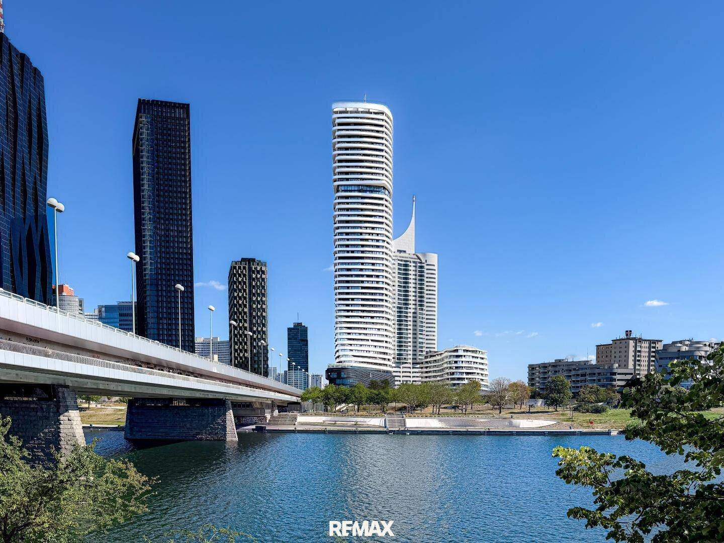 Beeindruckende moderne Architektur mit hohen Gebäuden und einer Brücke über dem Wasser.