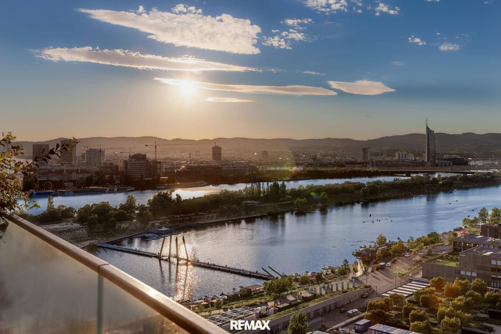 Sonnenuntergang über der Stadt mit weitem Blick auf den Fluss und die Skyline.