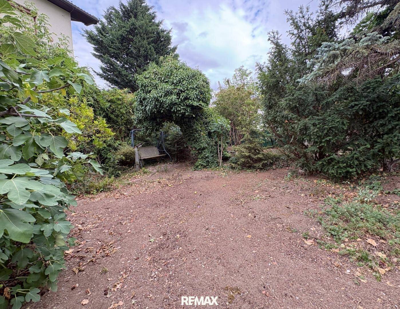 Großer Gartenbereich mit Schaukel und altem Baumbestand, bietet viel Platz im Freien.