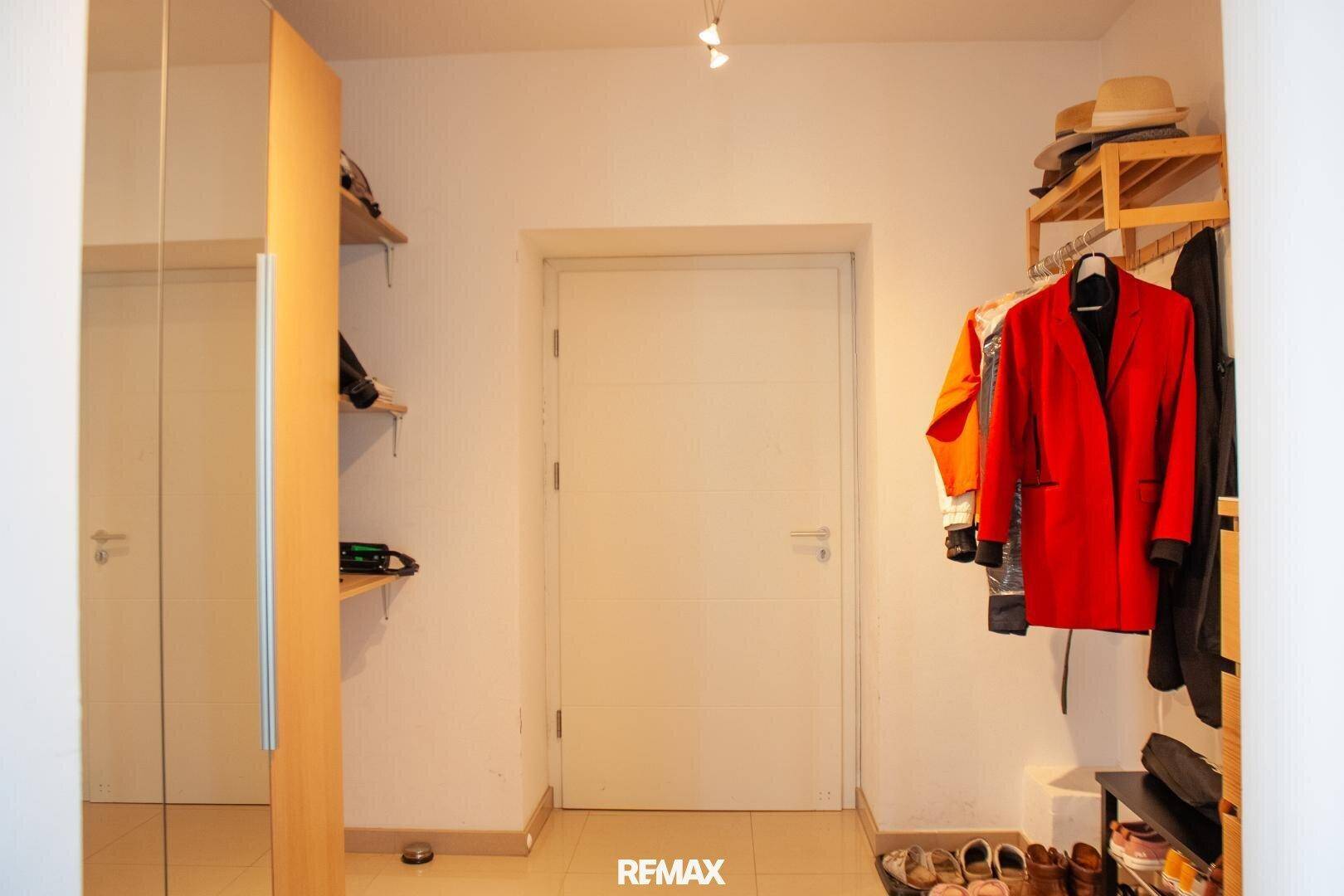 Ankleidebereich mit Spiegelschrank, Regalen und Kleiderstange für zusätzlichen Stauraum.