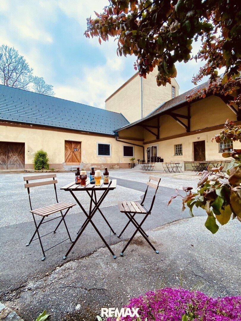 Gemütlicher Innenhof mit Tischen und Stühlen, ideal für entspannte Stunden im Freien.