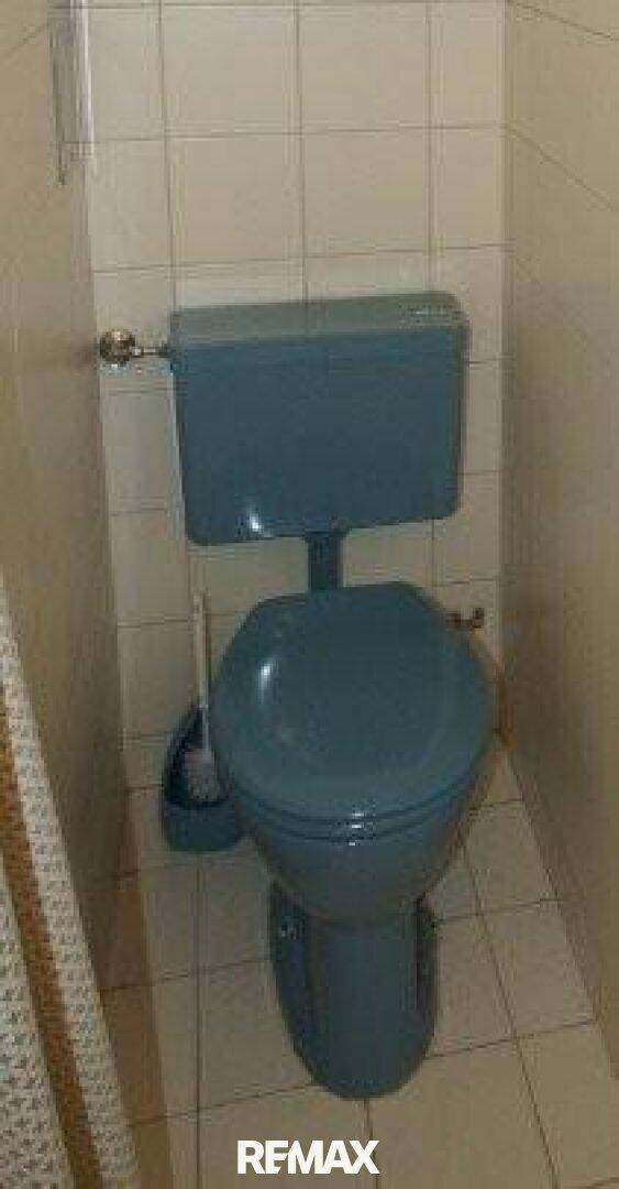 Separate Toilette mit blauer Keramik und weißen Fliesen.
