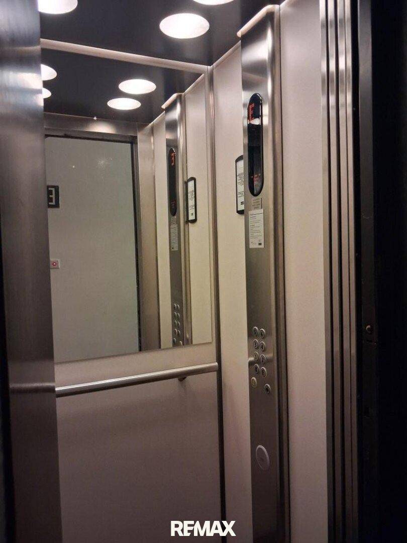 Moderner Aufzug mit Edelstahloberflächen und Spiegelelementen im Gebäude.