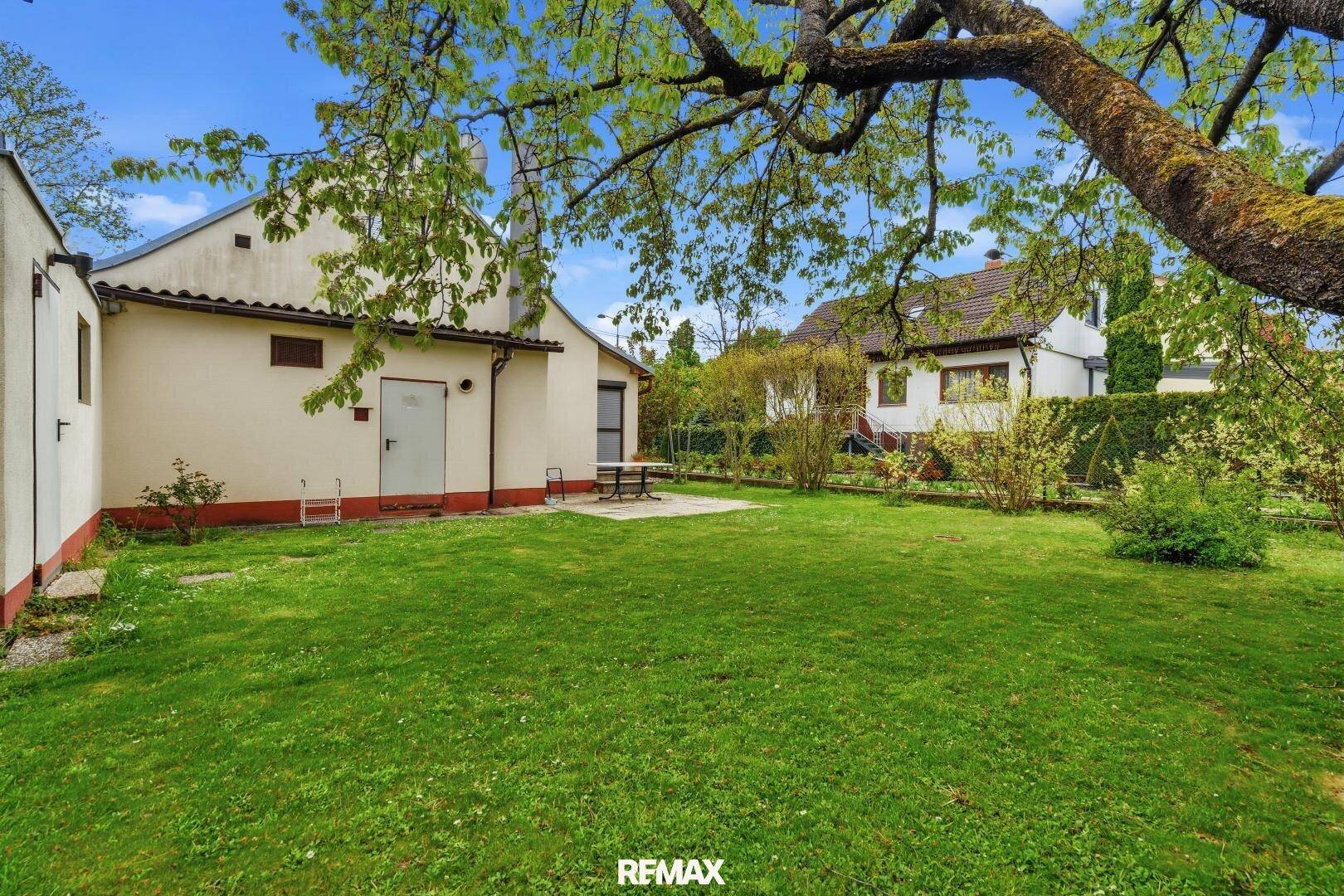 Weitläufiger Gartenbereich mit Blick auf das Haus und die umliegende grüne Landschaft.