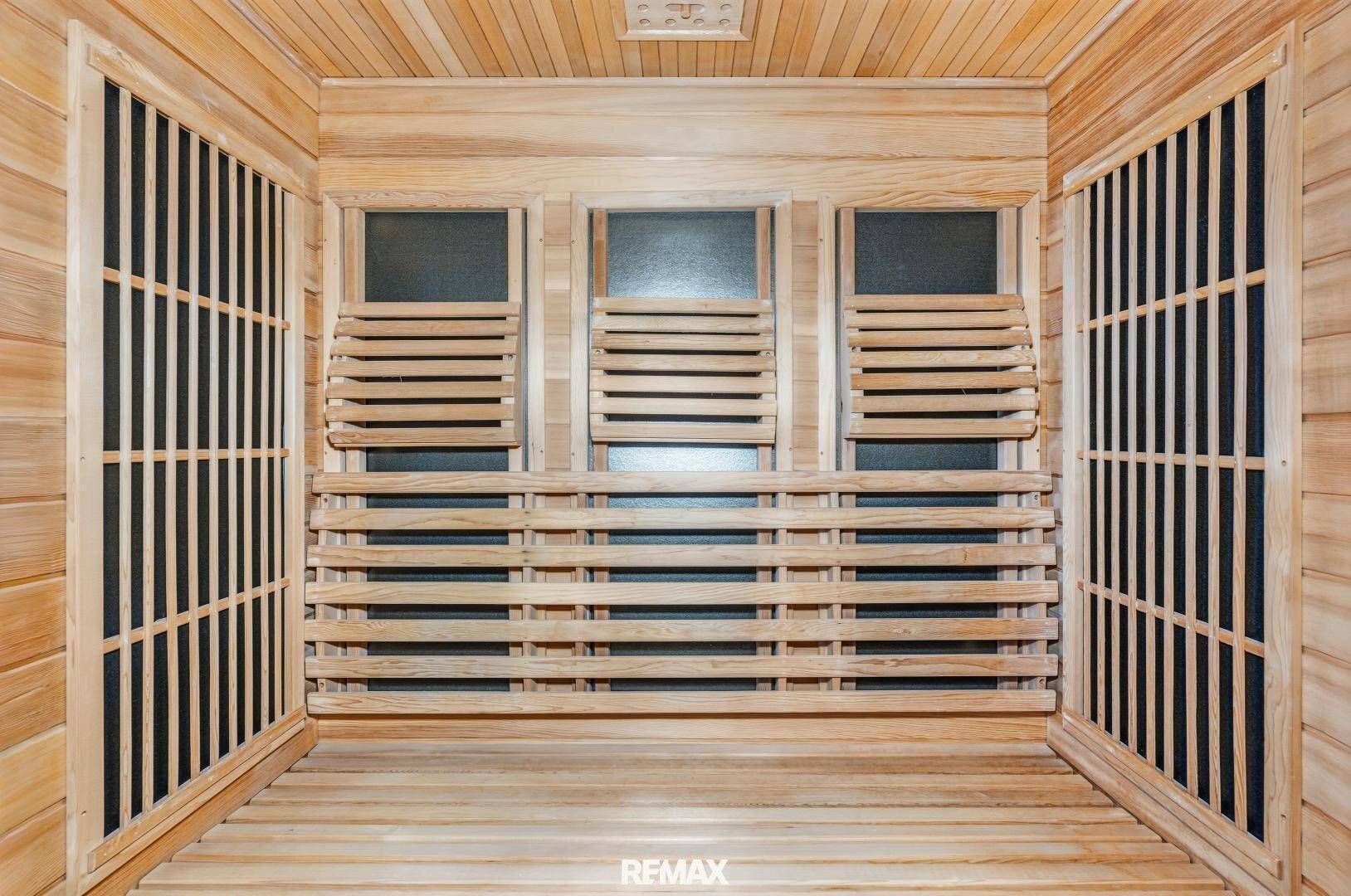 Innenansicht einer holzverkleideten Sauna-Kabine mit Sitzbänken.