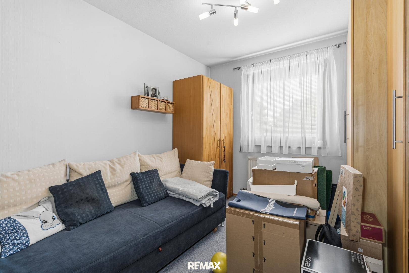 Gästezimmer mit Schlafsofa, Holzschrank und Stauraum.