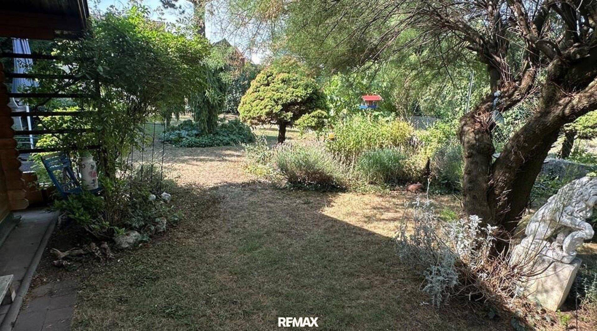 Weitläufiger Garten mit Rasenflächen, Sträuchern und Bäumen, ideal zur Entspannung.