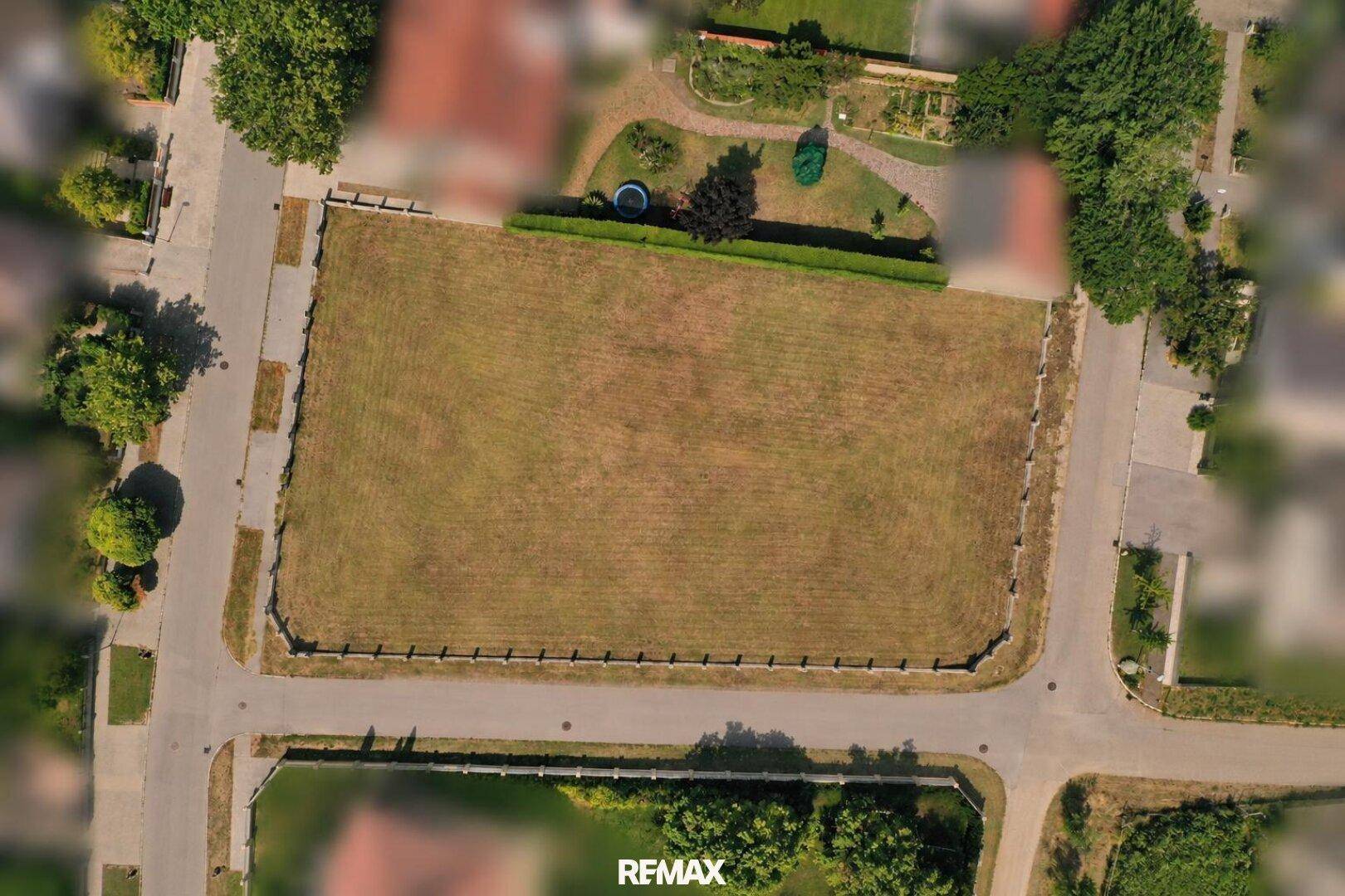 Vogelperspektive auf ein großes, trockenes Grundstück umgeben von Straßen und Wohnbebauung.