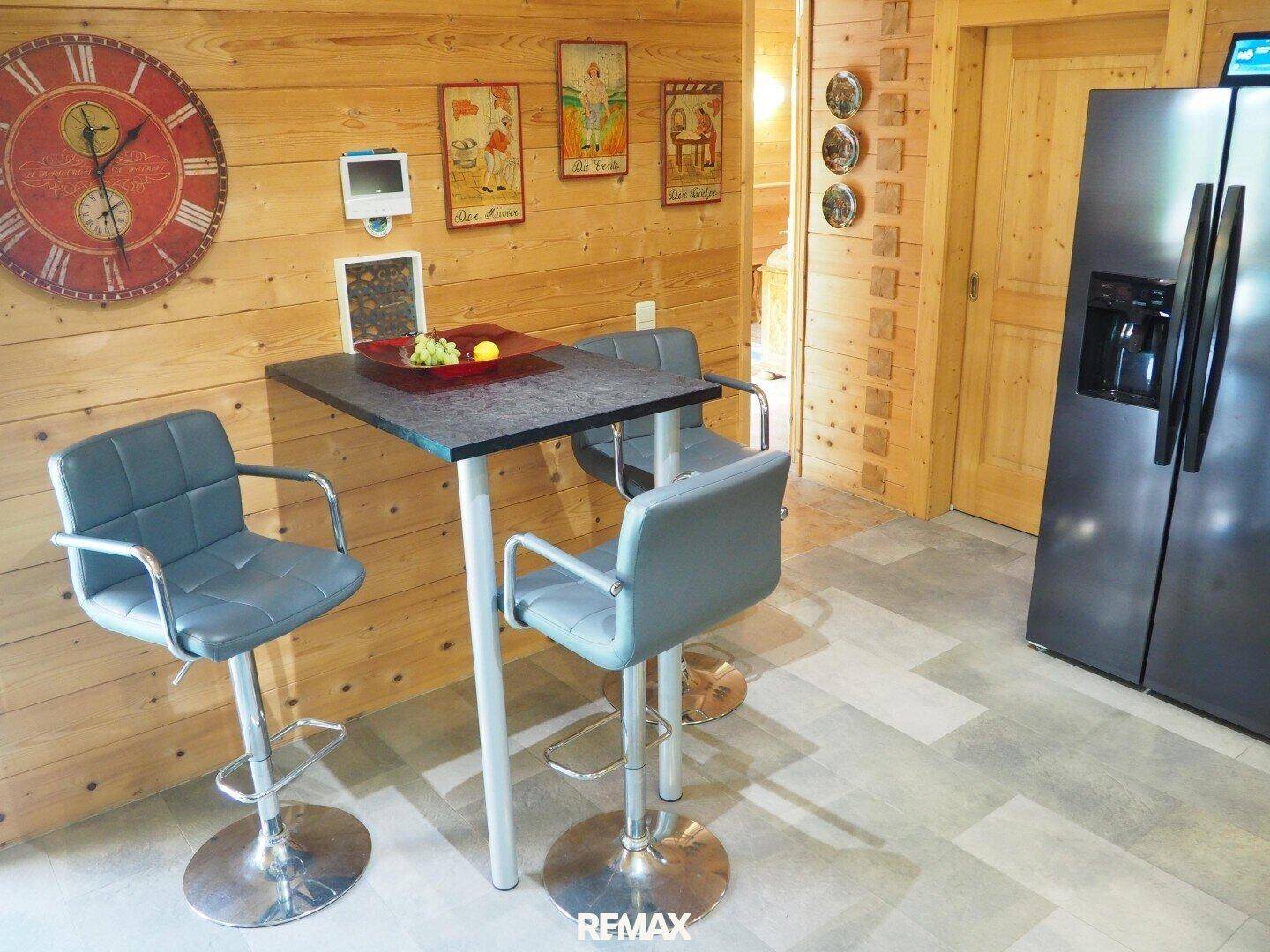 Kleiner Essbereich mit Bartisch und Hockern in der modernen Holzküche.