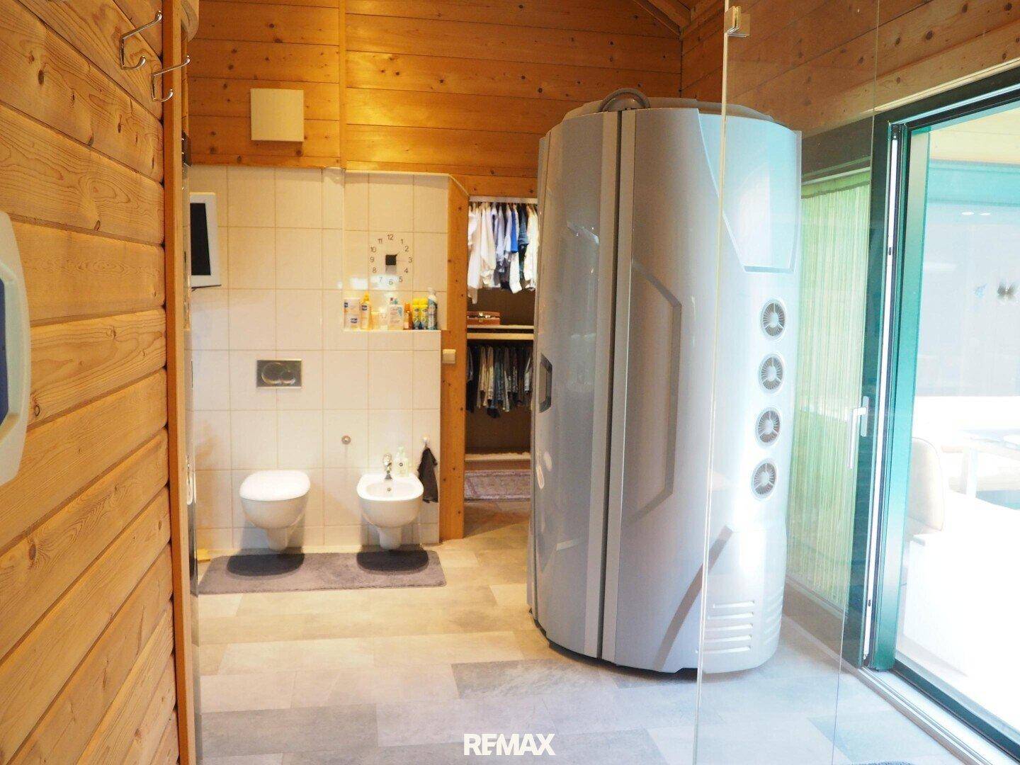 Badezimmer mit Solarium, Toilette, Bidet und Zugang zu einem begehbaren Kleiderschrank.