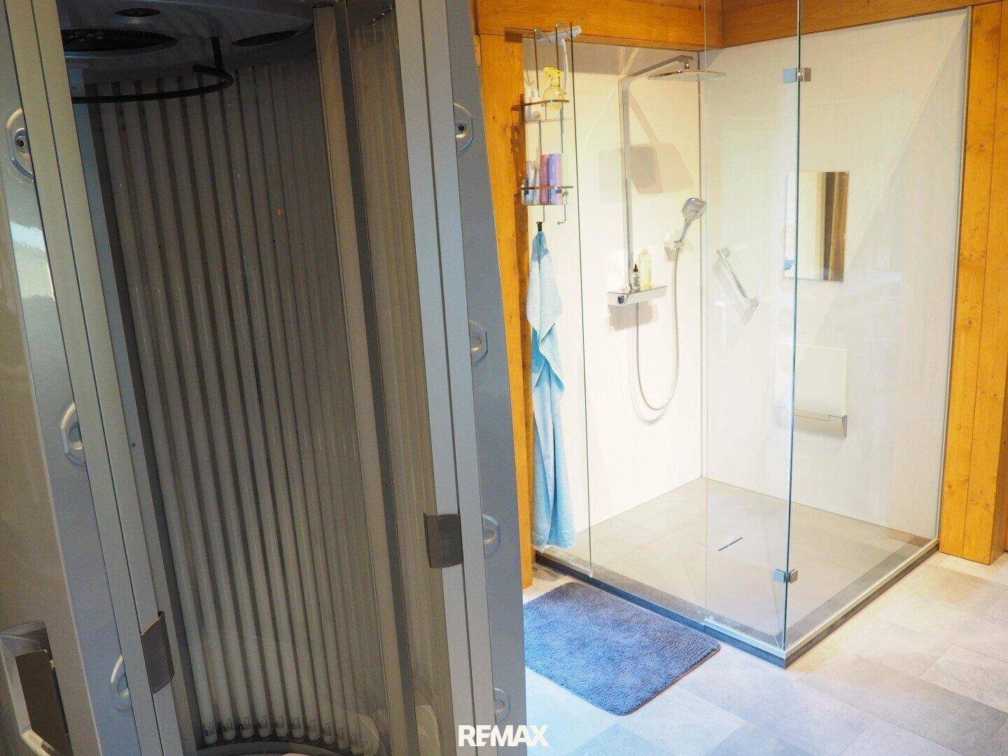 Helle begehbare Dusche mit moderner Ausstattung neben einem Solarium.