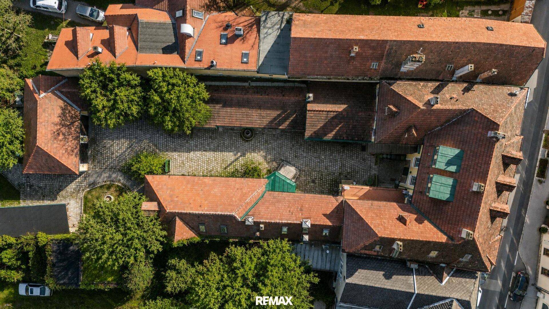 Weitläufige Luftaufnahme des gesamten Anwesens mit seinen Gebäuden und dem großen Innenhof.