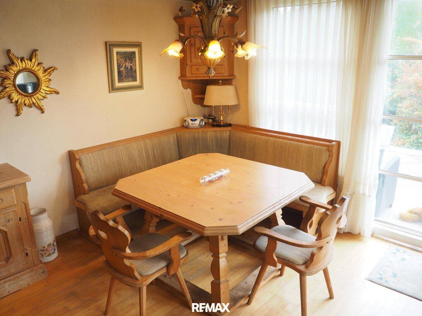 Gemütlicher Essbereich mit Eckbank, Holztisch und traditioneller Deckenleuchte.