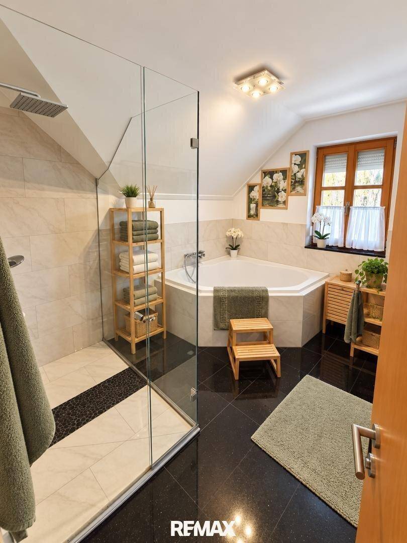 Modernes Badezimmer im Dachgeschoss mit Eckbadewanne, begehbarer Dusche und Fenster.