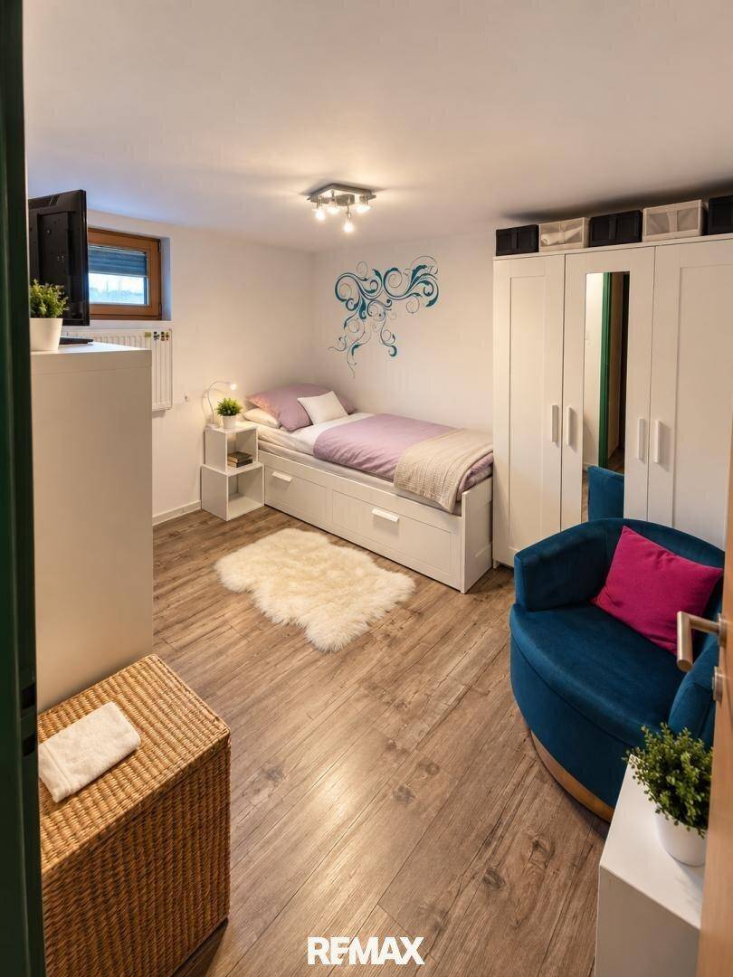 Helles Schlafzimmer im Untergeschoss mit Holzboden, Einzelbett und farbenfroher Dekoration.