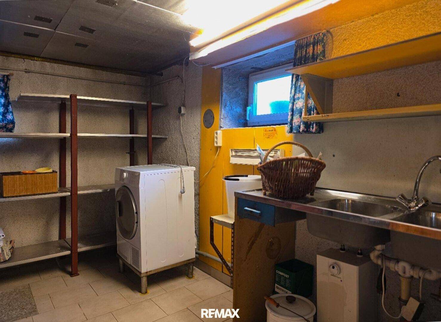 Funktionaler Waschraum im Keller mit Waschmaschine, Regalen und einem praktischen Waschbecken.