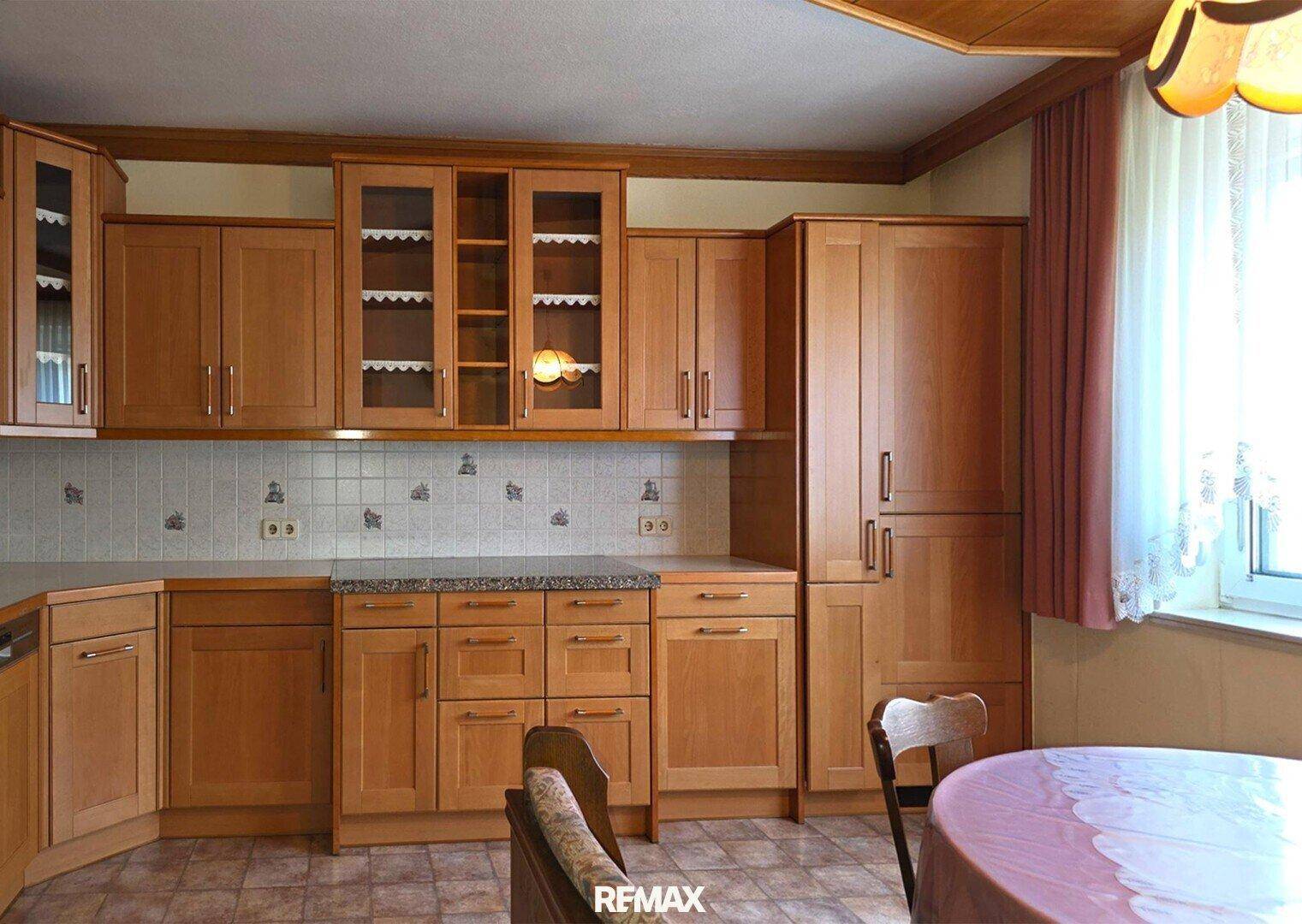 Traditionelle Holzküche mit Essbereich, Granitarbeitsplatte und gefliestem Spritzschutz.