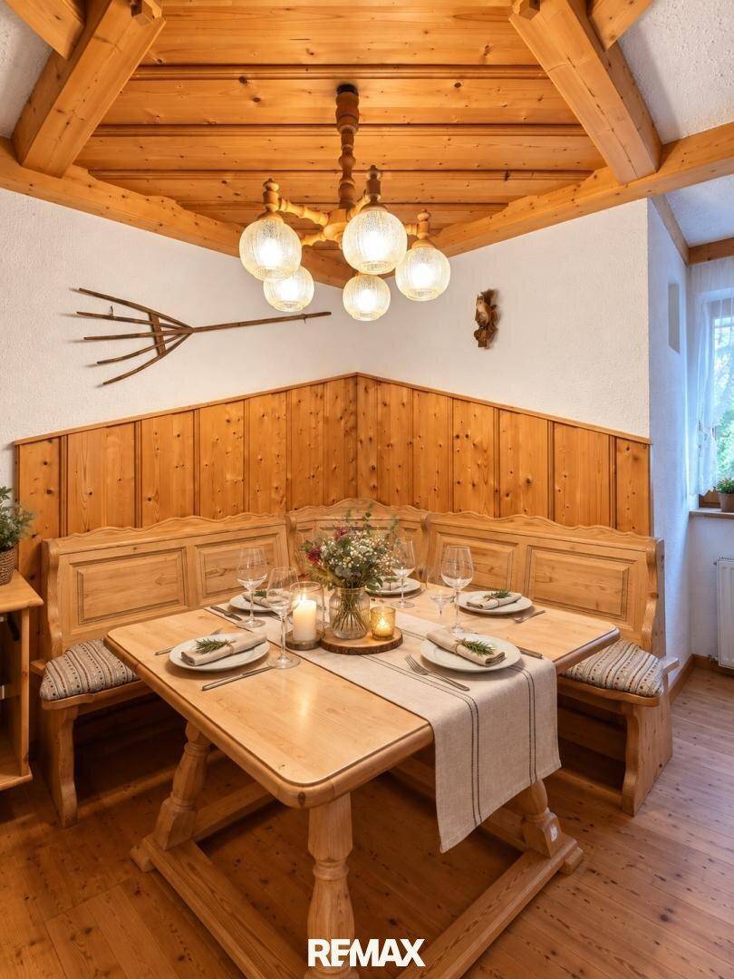 Traditioneller Essbereich mit Eckbank, Holztisch und rustikalem Kronleuchter.
