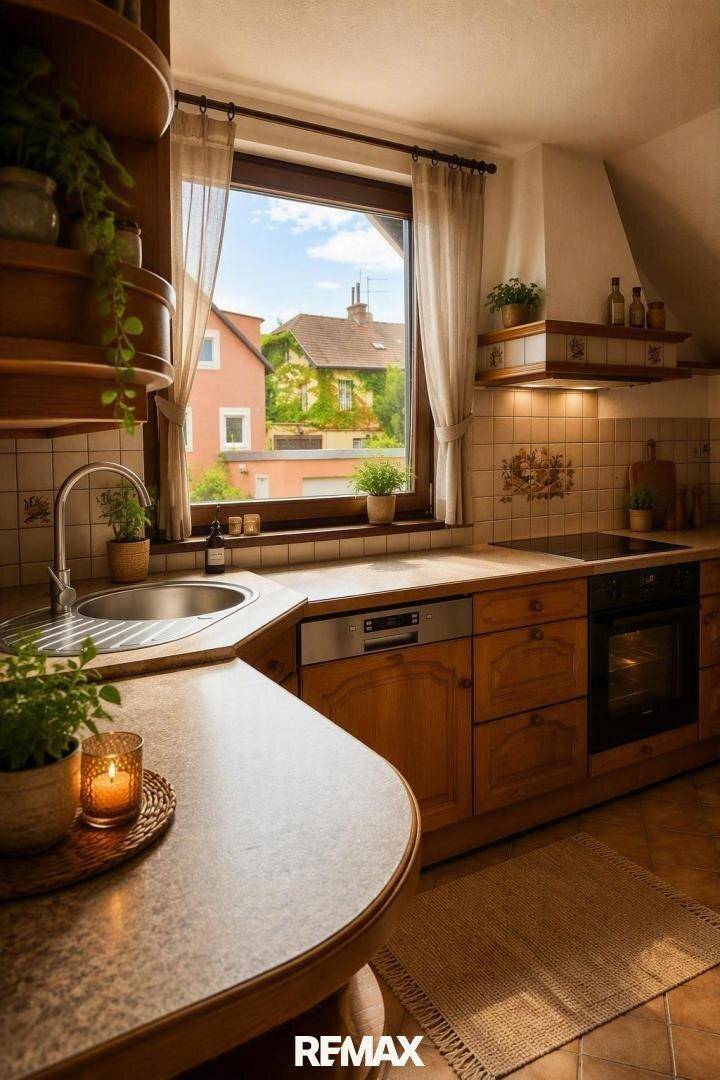 Traditionelle Küche mit Holzeinbauten, Spüle am Fenster und Blick ins Grüne.