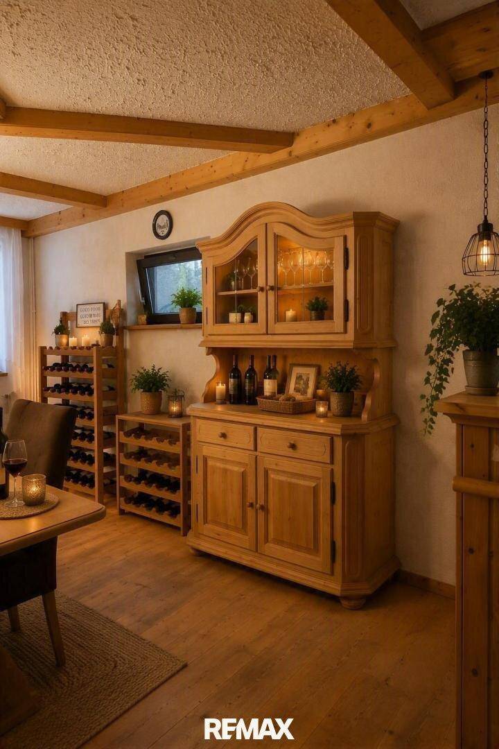 Rustikaler Wohn-Essbereich mit Holzbalken, Weinschränken und gemütlicher Beleuchtung.