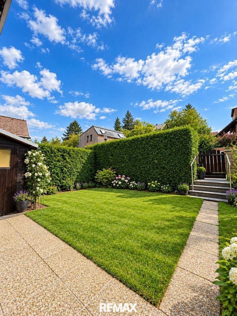 Gepflegter Garten mit Rasenfläche, hoher Hecke und einem kleinen Holzschuppen.
