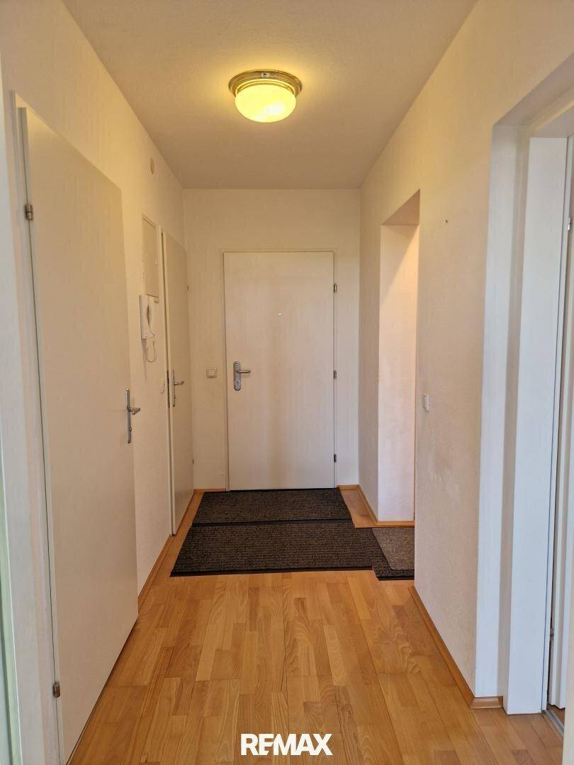 Heller Flur mit Holzparkettboden und mehreren Türen, der die verschiedenen Räume der Wohnung verbindet.