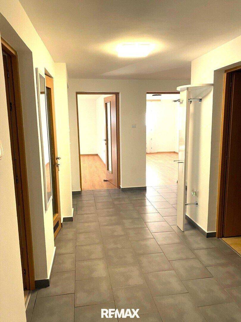 Geräumiger Flur mit Fliesenboden, der zu verschiedenen Zimmern führt und einen offenen Eindruck vermittelt.