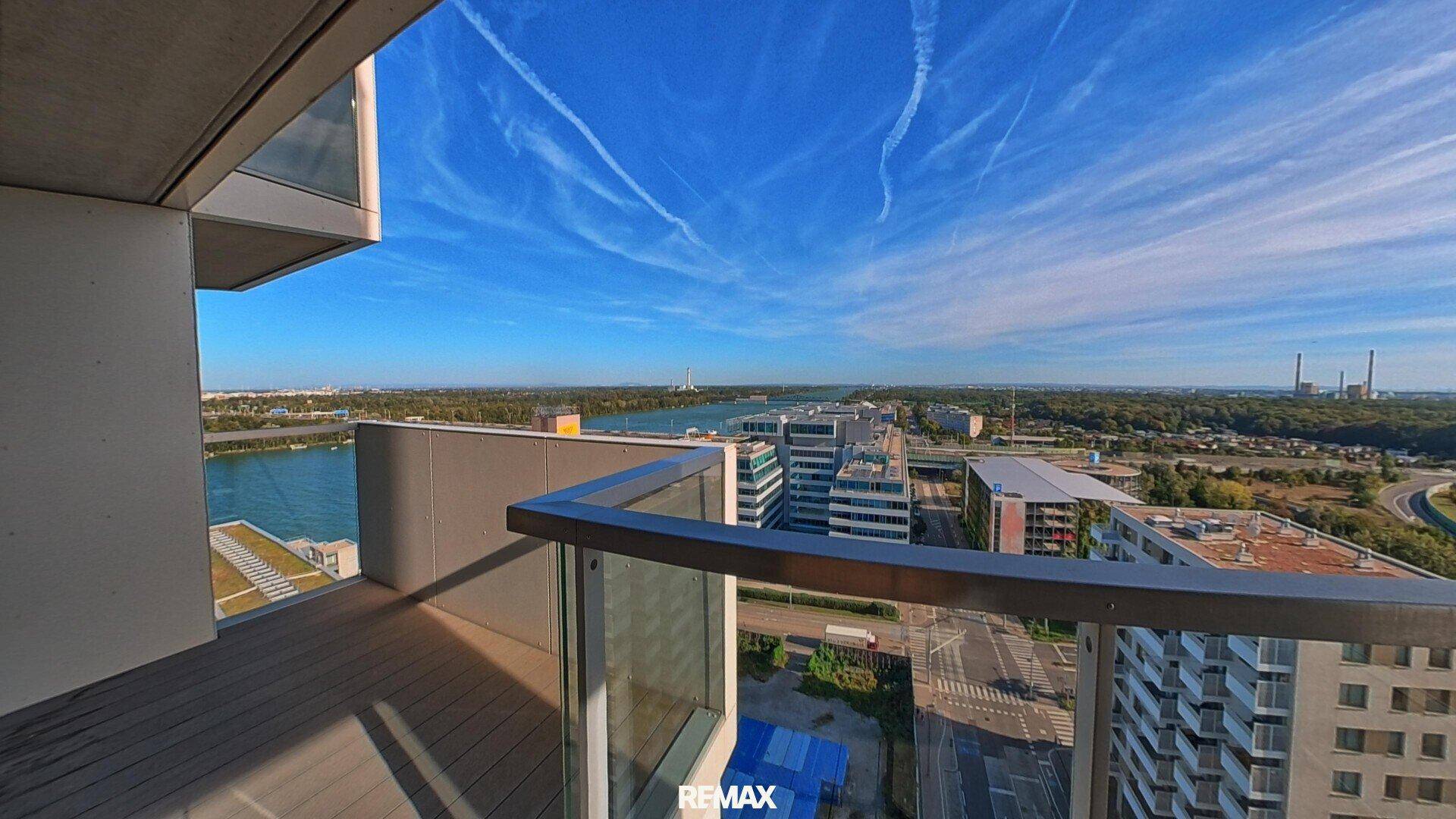 Heller Balkon mit Holzboden und weitem Blick auf den Fluss, Brücken und die Stadtlandschaft.