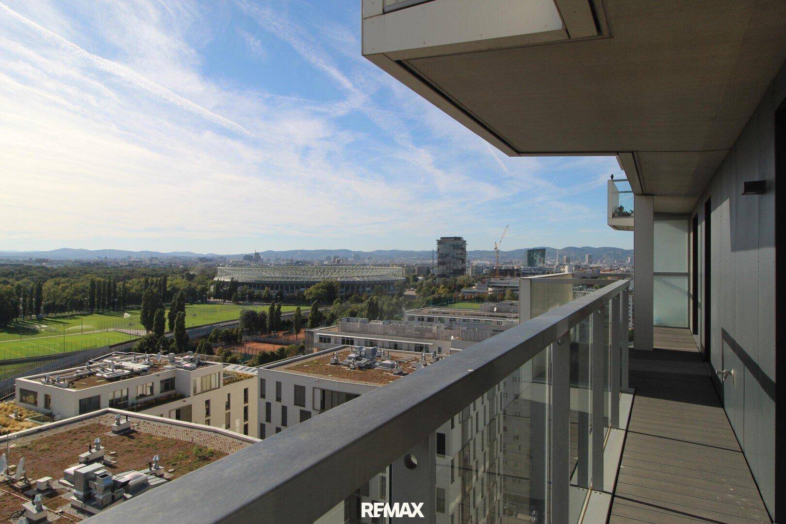 Breiter Balkon mit Holzboden und Panoramablick auf das Stadion und die umliegende Stadt.