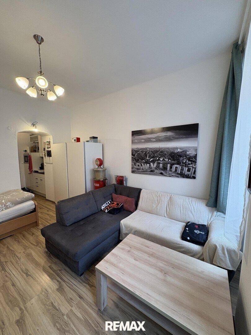 Gemütlicher Wohnbereich mit Sofa, Couchtisch und Blick zur Küchenzeile.