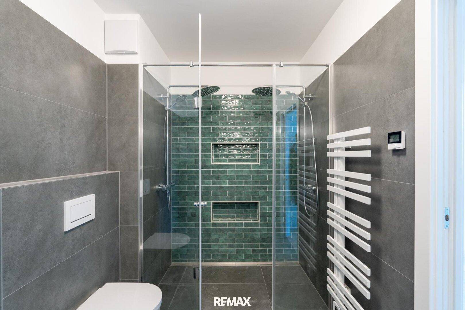 Modernes Badezimmer mit großer begehbarer Dusche, Regendusche und grauen Fliesen.