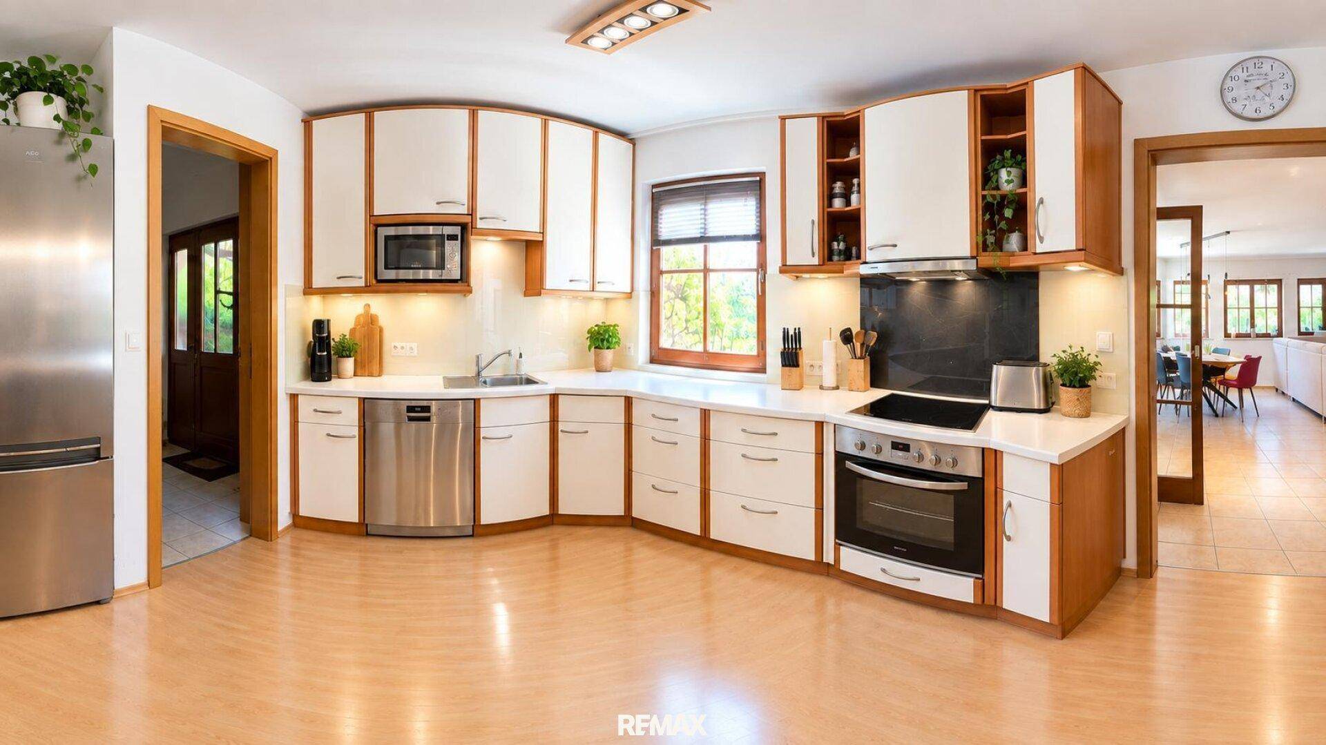 Geräumige Küche mit hellen Holzschränken, modernen Geräten und viel Arbeitsfläche.