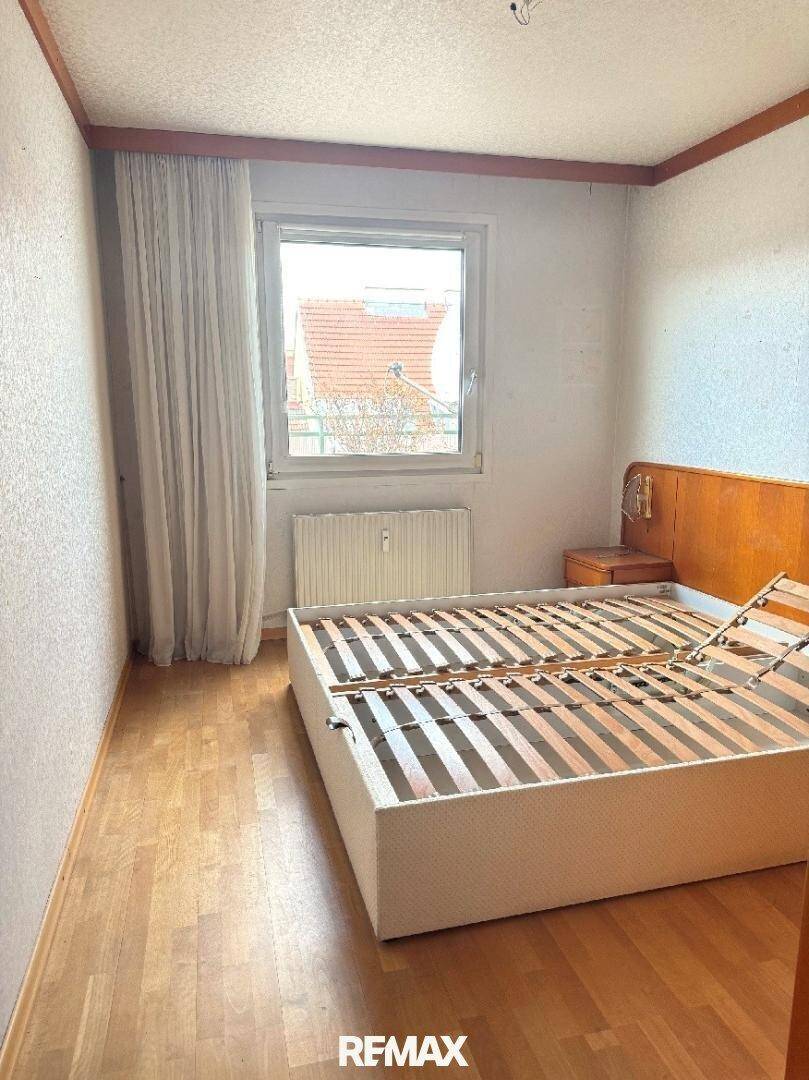 Schlafzimmer mit Holzfußboden und Bettgestell, bietet Potenzial für individuelle Gestaltung und Einrichtung.