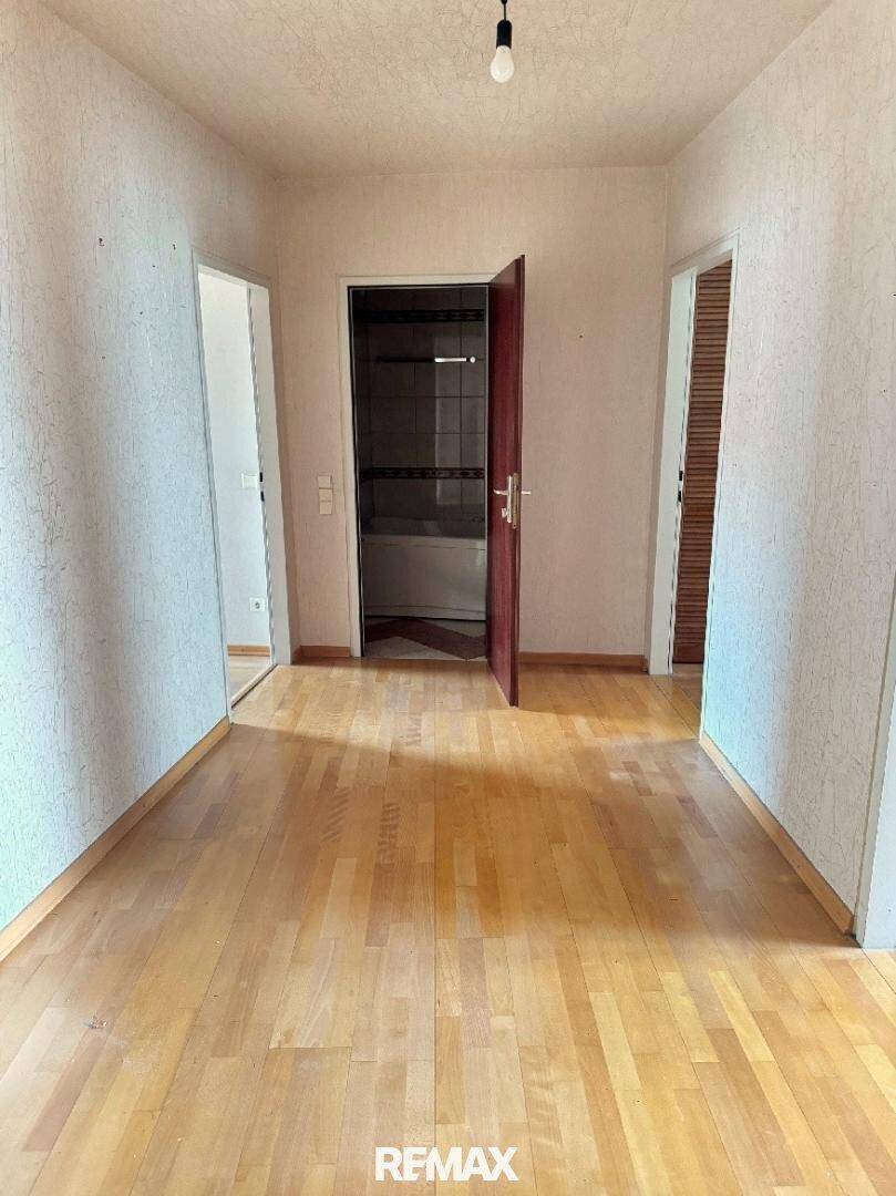 Heller Flur mit Holzfußboden, der zu den angrenzenden Räumen der Wohnung führt.